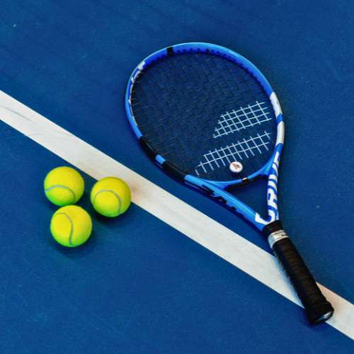 Tennis racket and tennis balls on a blue tennis court